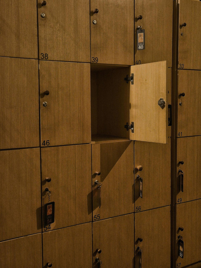 Open locker in a wooden cabinet room symbolizing the need for emergency locksmith response in unsecured business areas