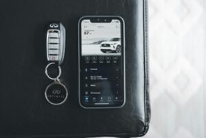 Infiniti key fob and smartphone representing the shift toward smart entry systems in modern cars.
