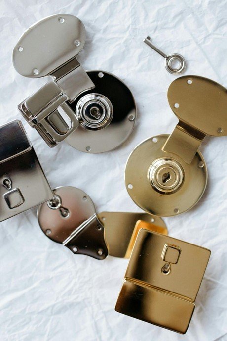 Close-up of silver and gold door locks with a silver key, symbolizing home security and lock installation.