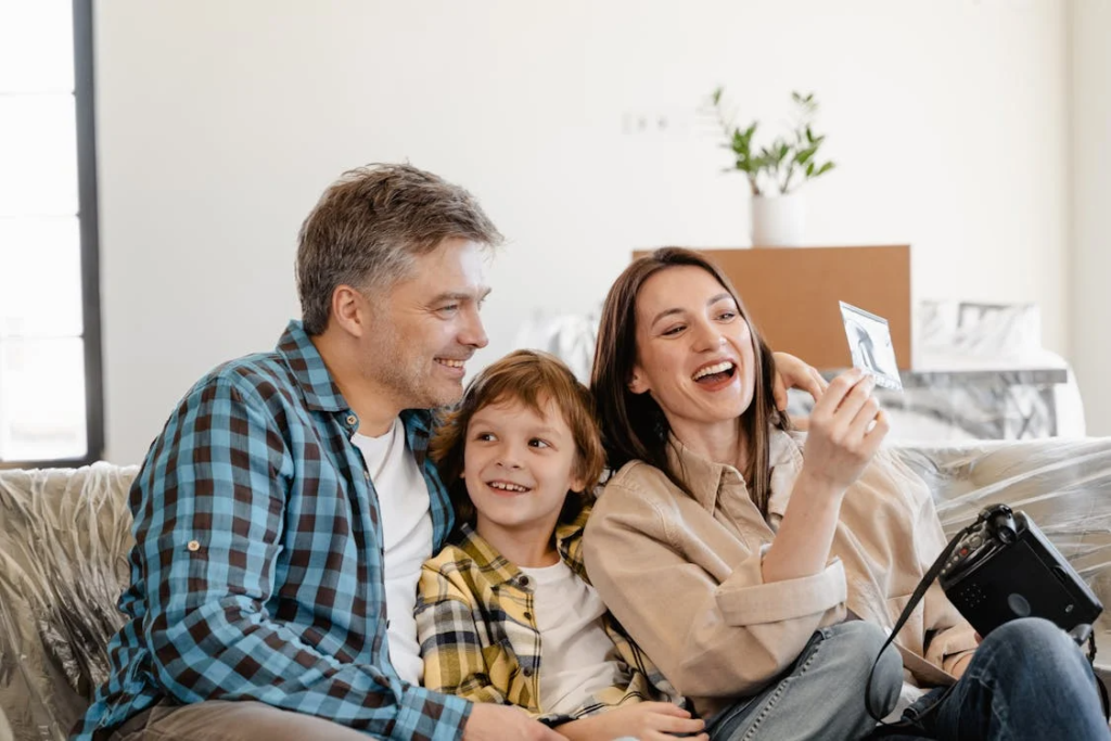A happy family sitting together at home, highlighting the importance of child safety with secure locks and doors.