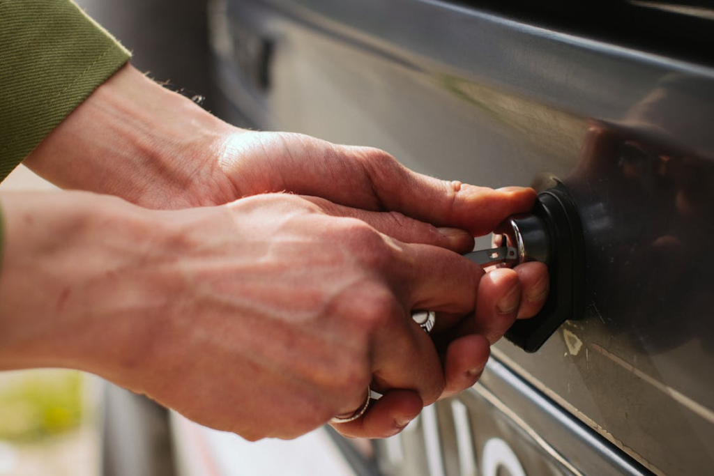 Hands repairing a vehicle ignition with tools by an auto locksmith in Las Vegas.
