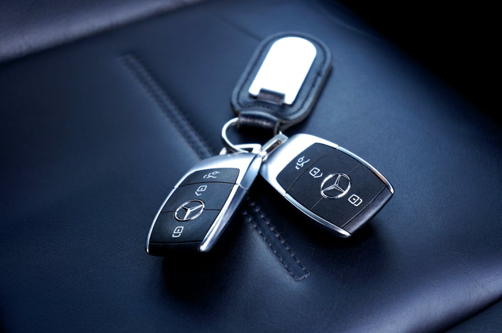 Modern luxury car key fobs placed on a leather seat for key fob replacement in Las Vegas.