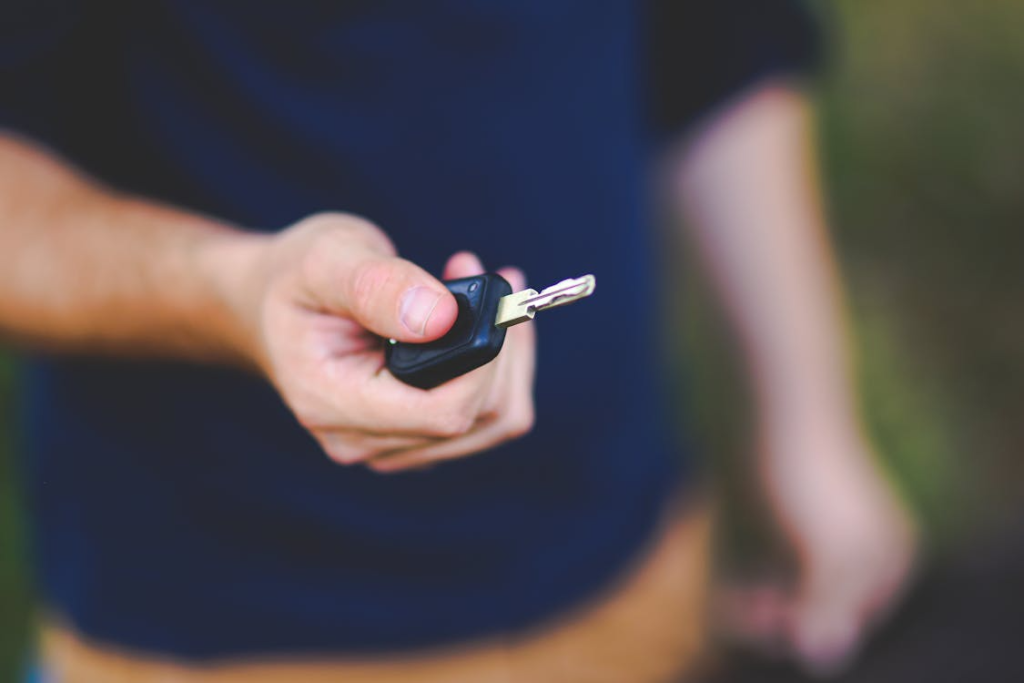 Close-up of a person holding a car key prepared by an automotive locksmith in Las Vegas, NV.