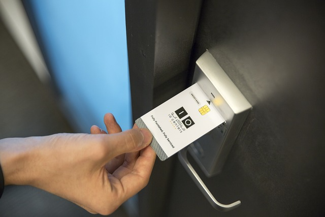 This photo shows a hand inserting a card into a card reader beside an office door
