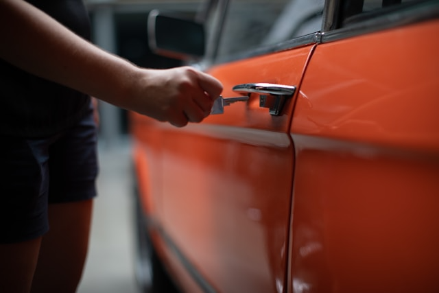This photo shows a driver opening a car door carefully after checking their keys