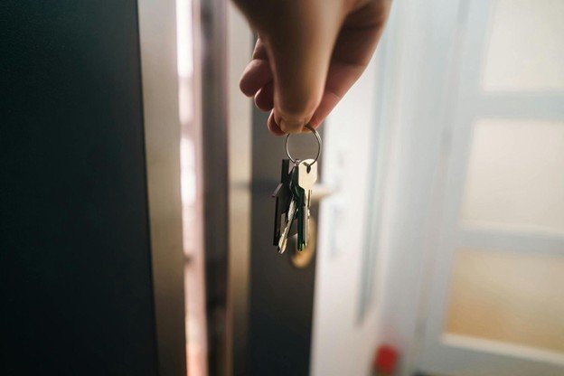 a person holding a bunch of keys in front of a doorway