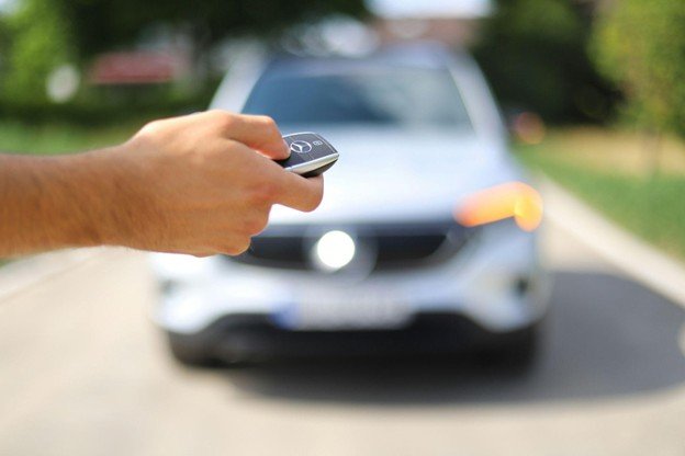 a person unlocking a car using keys